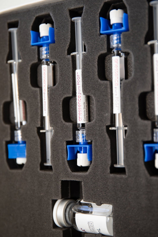 Close-up view of a professional medical kit containing pre-filled syringes labeled “ariessence pure PDGF,” organized neatly in a black foam case with blue safety caps.