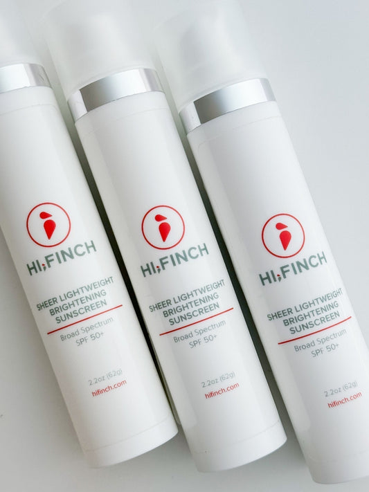 Three bottles of Hi, Finch Sheer Lightweight Brightening Sunscreen SPF 50+ with white packaging, silver accents, and red logo, arranged on a white background.