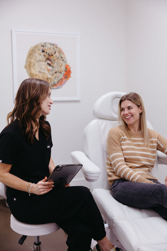 Brunette, female nurse practitioner discussing care plan with blonde female patient.