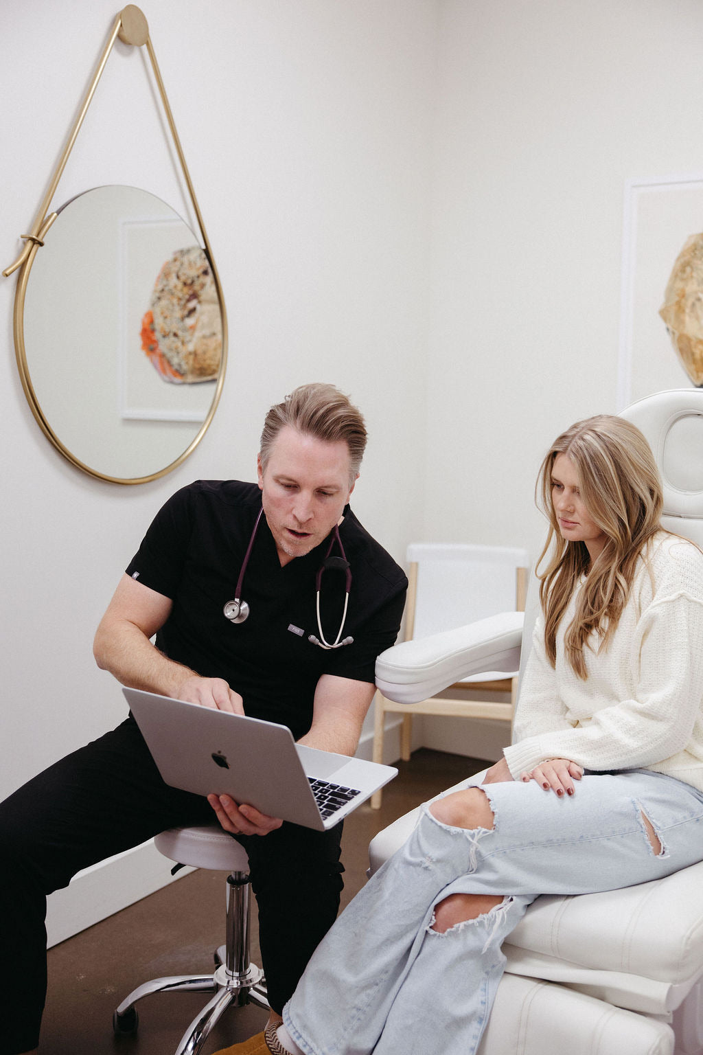 Dr. Kindred reviewing lab results with a patient during a medical consultation in a modern clinic