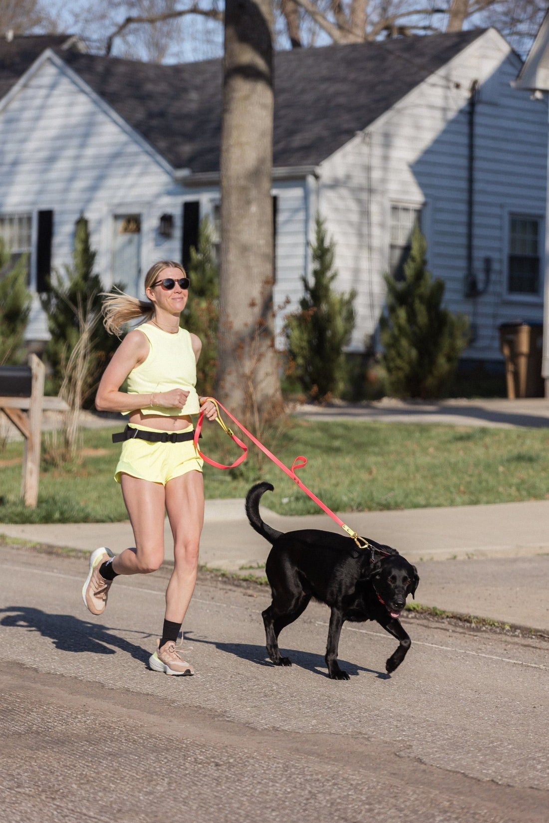 A woman running with her dog.